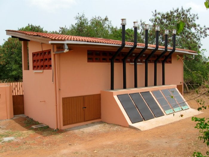 Dormitory toilet with solar-heated compost chambers and separate urine collector